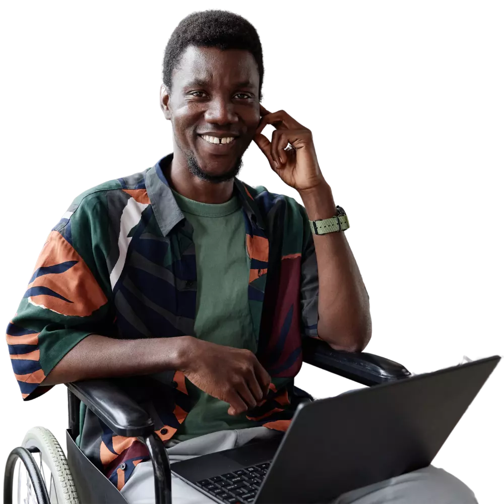 Happy disabled man in wheelchair using laptop and smiling at camera