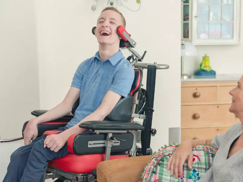 Disabled man in wheelchair happily laughing